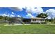 Landscaped backyard with pool and spacious green lawn at 112 Sunnyside Nw St, Port Charlotte, FL 33952
