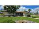 House with carport, mature landscaping, and a large grassy yard at 112 Sunnyside Nw St, Port Charlotte, FL 33952
