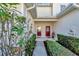 Front entry with red doors and neatly landscaped walkway at 1191 Jonah Dr, North Port, FL 34289