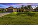 House exterior at dusk, featuring a well-maintained lawn at 1228 Lyle St, Port Charlotte, FL 33952