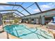 Enjoy this relaxing kidney-shaped pool with a screened enclosure and a spacious patio area at 1228 Lyle St, Port Charlotte, FL 33952