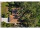House with brown roof and driveway, surrounded by lush trees at 21047 Baffin Ave, Port Charlotte, FL 33954