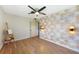 Light-filled bedroom with designer wallpaper, light fixtures, hardwood flooring, and a ceiling fan at 23 Tiffany St, Englewood, FL 34223