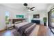 Bright main bedroom with hardwood floors, a sleek ceiling fan, and a sliding glass door at 23 Tiffany St, Englewood, FL 34223