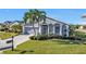 Well-maintained home with gray exterior, palm trees, and a manicured lawn at 24415 Buckingham Way, Punta Gorda, FL 33980