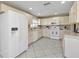 Efficient kitchen with white cabinetry, stainless steel appliances, and tile floors at 24415 Buckingham Way, Punta Gorda, FL 33980