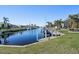 Private dock and canal access with lush landscaping and palm trees at 2501 Rio Largo Ct, Punta Gorda, FL 33950