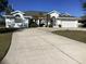 Front view of a single-Gathering home with a large driveway and green lawn at 25200 Derringer Rd, Punta Gorda, FL 33983
