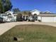 White two-story house with a gray roof, two-car garage, and a well-maintained lawn at 25200 Derringer Rd, Punta Gorda, FL 33983