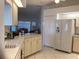 Kitchen with white cabinets, a large refrigerator, and a view into the living area at 25200 Derringer Rd, Punta Gorda, FL 33983