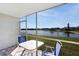 Screened-in patio offers stunning lake views with table and chairs at 3310 Loveland Blvd # 2304, Punta Gorda, FL 33980