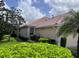 Tan house with tile roof, lush landscaping, and a large palm tree at 4371 Whispering Oaks Dr., North Port, FL 34287