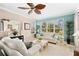 Relaxing living room with white sofas and large windows overlooking a golf course at 4371 Whispering Oaks Dr., North Port, FL 34287