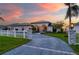 Charming home at sunset with a well-manicured lawn, decorative lighting, and an inviting arched entryway at 5117 Collingswood Blvd, Port Charlotte, FL 33948