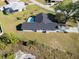 Aerial view showcasing a single-story house, pool, and surrounding landscape at 7359 Van Lake Dr, Englewood, FL 34224