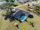 Aerial view of home with in-ground pool, lush lawn, and well-maintained landscaping near a waterway at 7359 Van Lake Dr, Englewood, FL 34224