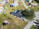 Aerial view of home with pool, driveway, mature trees, and neat landscaping at 7359 Van Lake Dr, Englewood, FL 34224