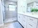 Elegant bathroom features a glass enclosed shower and vanity with double sinks and modern fixtures at 7359 Van Lake Dr, Englewood, FL 34224