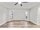 Bright bedroom featuring hardwood floors, natural light, and a ceiling fan at 7359 Van Lake Dr, Englewood, FL 34224
