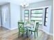 Bright dining area with a bay window, hardwood floors, modern chandelier, and stylish green chairs at 7359 Van Lake Dr, Englewood, FL 34224