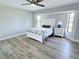 Bright main bedroom featuring hardwood floors, a ceiling fan, a bed, and great natural light at 7359 Van Lake Dr, Englewood, FL 34224