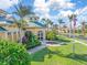 Beautiful clubhouse with lush landscaping, palm trees, and an American flag in a tropical community at 8882 Peregrine Way, North Port, FL 34287