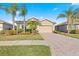 Exterior of single-Gathering home with palm trees, landscaping and a paved driveway at 8882 Peregrine Way, North Port, FL 34287