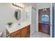 Bathroom vanity with light fixture, mirror, and wooden cabinetry at 921 Great Falls Nw Ter, Port Charlotte, FL 33948