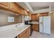 Kitchen with wood cabinets, white countertops, and a white refrigerator at 921 Great Falls Nw Ter, Port Charlotte, FL 33948