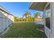 Backyard features a lush lawn, mature palm trees, a canal view, and a boat dock at 130 Arlington Ne Ct, Port Charlotte, FL 33952