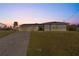 Well-maintained front exterior featuring a long driveway and mature landscaping at 130 Arlington Ne Ct, Port Charlotte, FL 33952