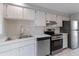 Kitchen with stainless steel appliances and light wood cabinets at 130 Arlington Ne Ct, Port Charlotte, FL 33952