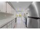 Bright kitchen featuring stainless steel appliances, white cabinets, and views to the lanai at 130 Arlington Ne Ct, Port Charlotte, FL 33952