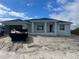 New construction home with a light gray exterior, dark roof, and an attached two-car garage at 13541 Jeronimo Ln, Port Charlotte, FL 33981