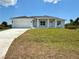 Beautiful single-story home features a two-car garage, well-manicured lawn, and light blue exterior paint at 13541 Jeronimo Ln, Port Charlotte, FL 33981
