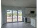 View of the open living area with sliding glass doors and a partial view of the kitchen at 13541 Jeronimo Ln, Port Charlotte, FL 33981