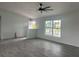 Open living area with wood-look tile flooring, two large windows, and a ceiling fan at 13541 Jeronimo Ln, Port Charlotte, FL 33981