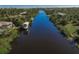 An aerial view along the waterway, highlighting lush landscaping and boat docks for this waterfront community at 15600 Aldama Cir, Port Charlotte, FL 33981