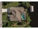 Aerial view of the home showing the pool, canal access, boat lift, and surrounding landscaping at 15600 Aldama Cir, Port Charlotte, FL 33981