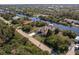 Aerial view showcasing the home's canal-front location, boat dock, and lush surroundings at 15600 Aldama Cir, Port Charlotte, FL 33981