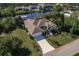 A high angle aerial view of the home highlighting the lush landscaping and long driveway at 15600 Aldama Cir, Port Charlotte, FL 33981