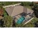 Aerial view of screened in pool and back of house surrounded by lush landscaping at 15600 Aldama Cir, Port Charlotte, FL 33981