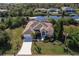An aerial view of a well-maintained home featuring a pristine lawn and access to a tranquil canal at 15600 Aldama Cir, Port Charlotte, FL 33981
