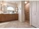Neutral bathroom featuring double sink vanity, large mirror, walk-in shower, and linen closet at 15600 Aldama Cir, Port Charlotte, FL 33981