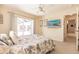 Bedroom featuring ceiling fan, large TV, slider doors to patio, and beach-themed wall art at 15600 Aldama Cir, Port Charlotte, FL 33981