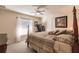 Bedroom with a four-poster bed, ceiling fan, large windows, and a view of the backyard at 15600 Aldama Cir, Port Charlotte, FL 33981