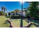 Charming home featuring a manicured front yard, well-maintained landscaping, and a unique putting green at 15600 Aldama Cir, Port Charlotte, FL 33981