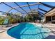 Screened-in pool with covered lanai, lush landscaping, lounge chairs, and patio furniture at 15600 Aldama Cir, Port Charlotte, FL 33981