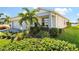 House exterior with gray garage door and lush landscaping at 15976 Shoreline Dr, Punta Gorda, FL 33982