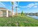 Well-maintained backyard with screened lanai overlooking a serene lake, enhanced by swaying palm trees at 16891 Caracara Pl, Punta Gorda, FL 33982